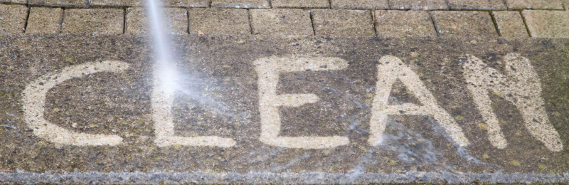 Clean written into the sidewalk with a pressure washer